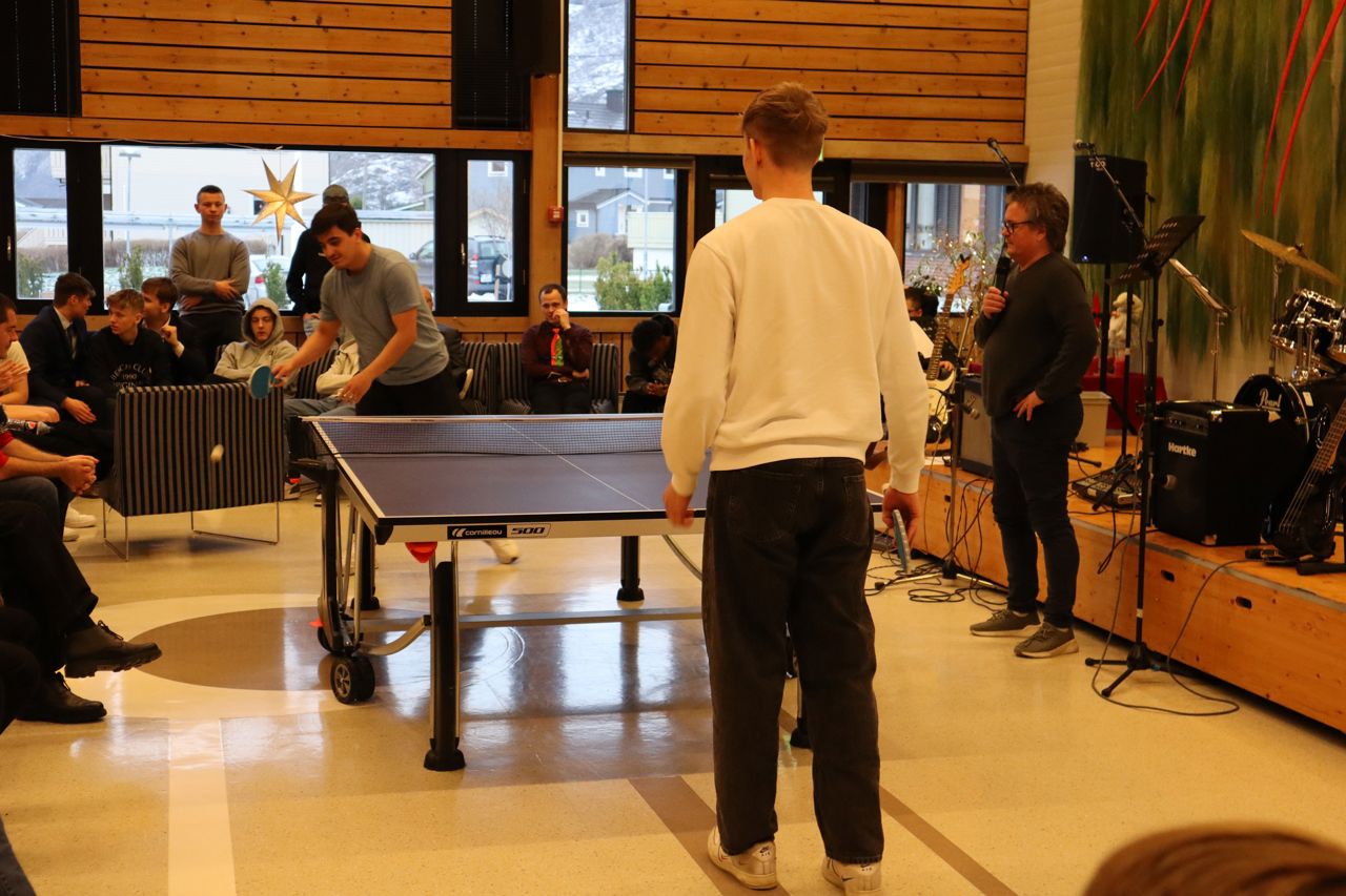 To elevar som spelar finale i bordtennis. Kampen blir spelt i kantine på juleavslutningen med resten av skulen som publikum.